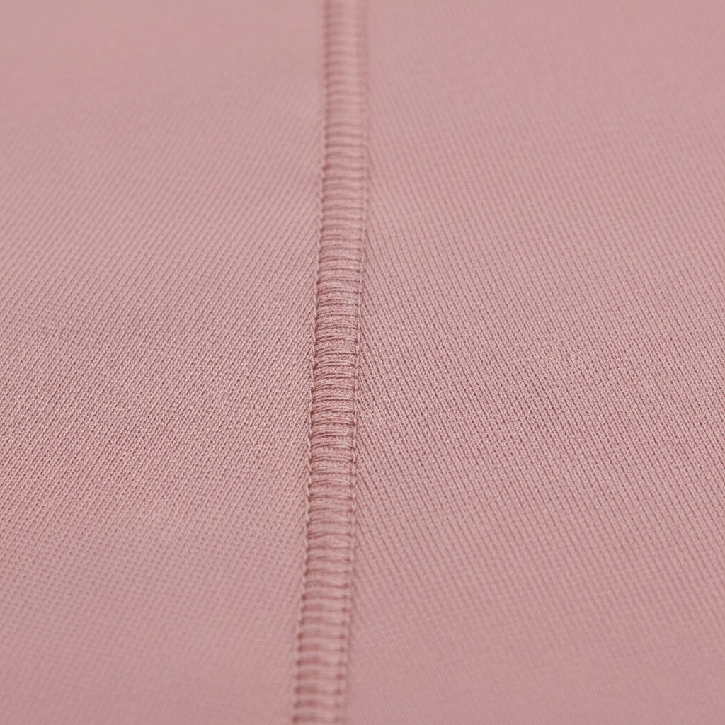 T-shirt manches longues cintre femme rose poudré, zoom matière macro sur couture princesse courbée et texture du tissu.