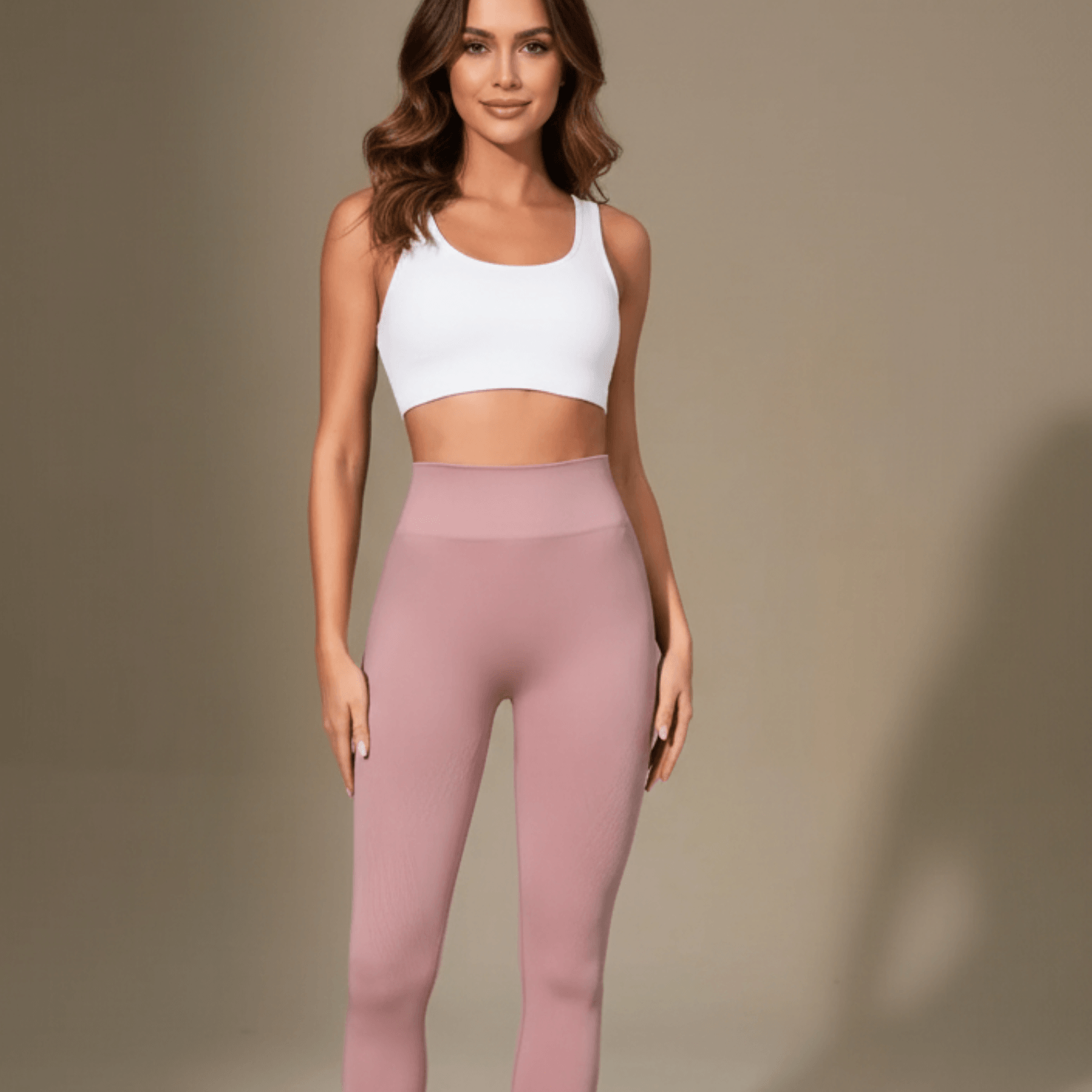 Legging anti cellulite femme rose poudré vue de face avec pose assurance et confiance en studio beige minimaliste
