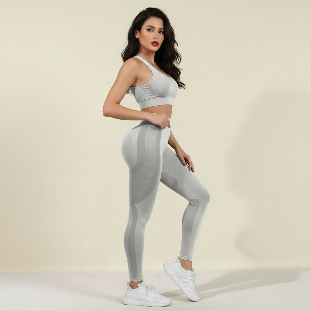 Legging anti cellulite gris clair, vue de profil, pose élégante, brassière assortie, studio crème.