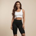Short femme sport noir, debout, vue de face, coupe mi-cuisse taille haute, studio minimaliste crème