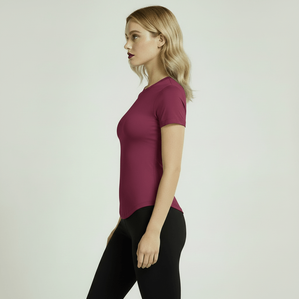 T-shirt de Sport Femme compression framboise, vue de profil sur femme blonde, legging noir, studio ivoire minimaliste